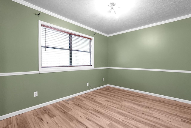 unfurnished room with baseboards, crown molding, a textured ceiling, and wood finished floors