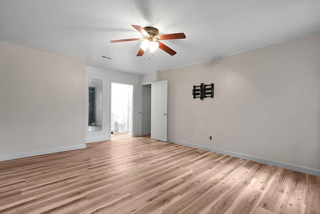 spare room featuring light wood-type flooring, baseboards, a ceiling fan, and visible vents