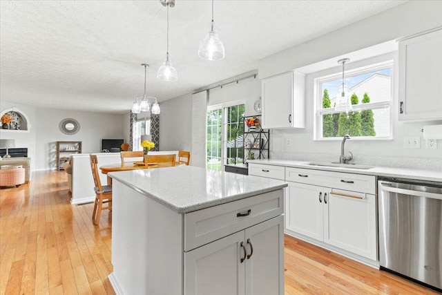 830 Avalon Dr, Pickerington, OH 43147 - kitchen featuring dishwasher, a sink, a textured ceiling, open floor plan, and light wood-style floors