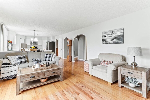 830 Avalon Dr, Pickerington, OH 43147 - living area with arched walkways, a textured ceiling, and light wood-type flooring