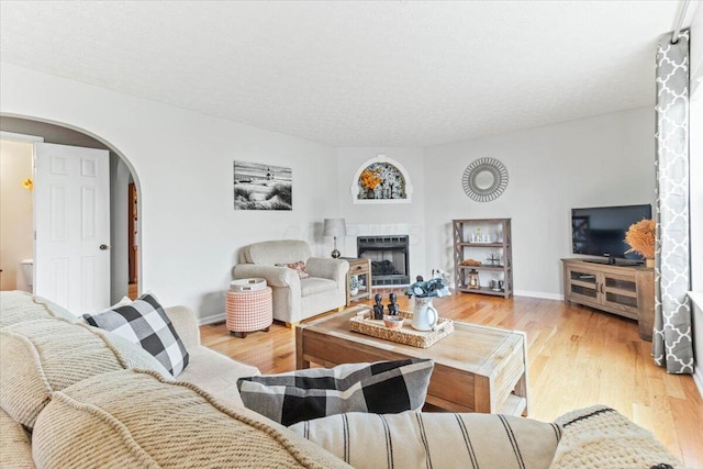830 Avalon Dr, Pickerington, OH 43147 - living room featuring arched walkways, wood finished floors, a fireplace, and baseboards