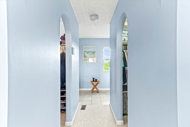 830 Avalon Dr, Pickerington, OH 43147 - hallway featuring arched walkways, a textured ceiling, and baseboards