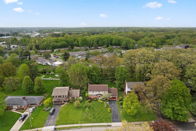 drone / aerial view featuring a wooded view and a residential view