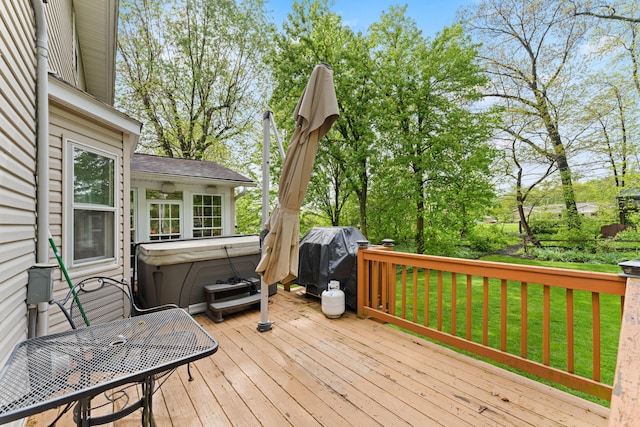 wooden terrace featuring a lawn and a hot tub