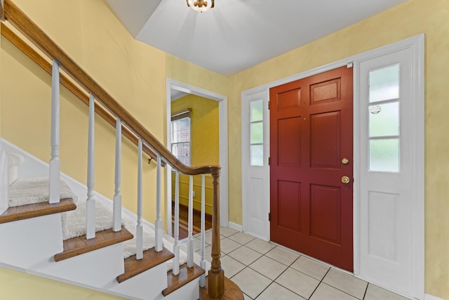 foyer entrance with plenty of natural light, tile patterned flooring, baseboards, and stairs
