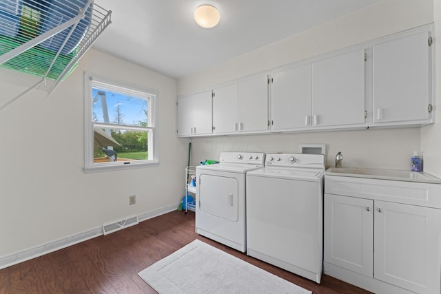 clothes washing area featuring baseboards, visible vents, cabinet space, separate washer and dryer, and dark wood-style floors