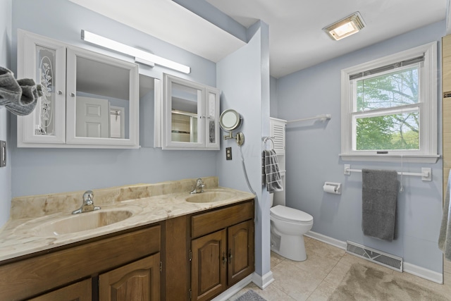 bathroom featuring a sink, double vanity, toilet, and visible vents