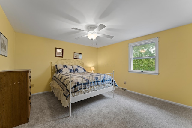 bedroom with baseboards, a ceiling fan, visible vents, and carpet