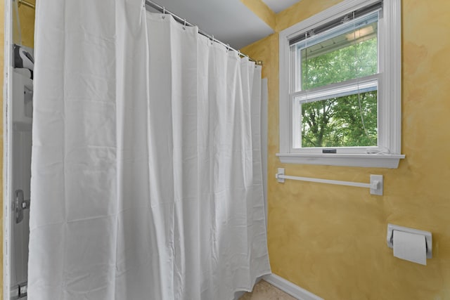 bathroom with baseboards and a shower with curtain