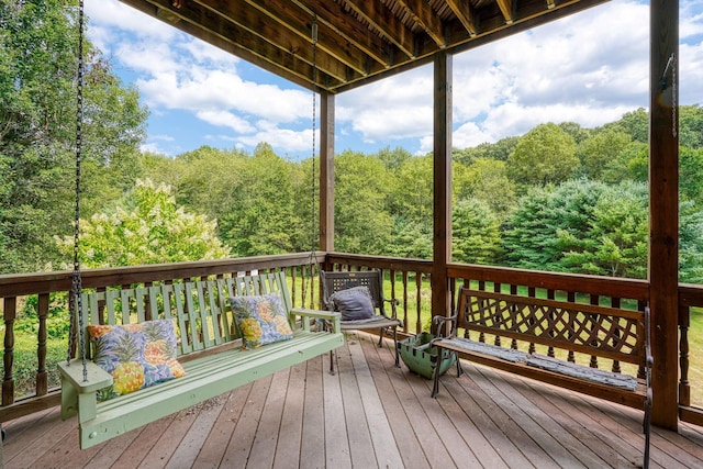 wooden terrace featuring a forest view