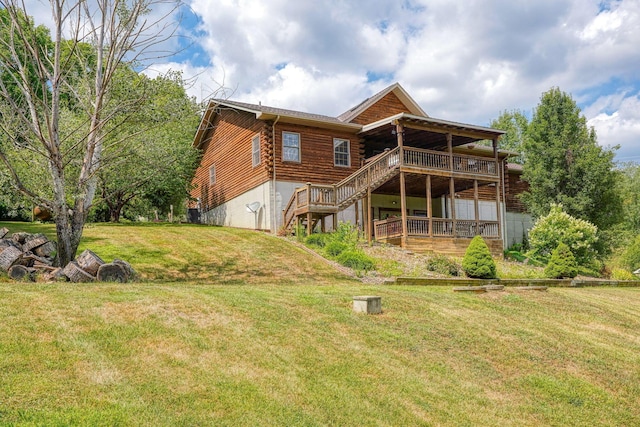 rear view of house featuring a yard, a wooden deck, and stairs