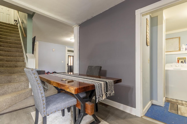 dining room with washer / dryer, wood finished floors, baseboards, and stairs