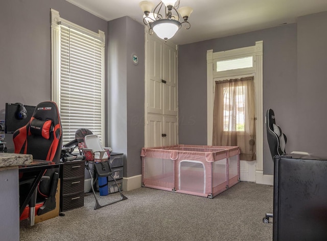 carpeted home office featuring baseboards and a chandelier