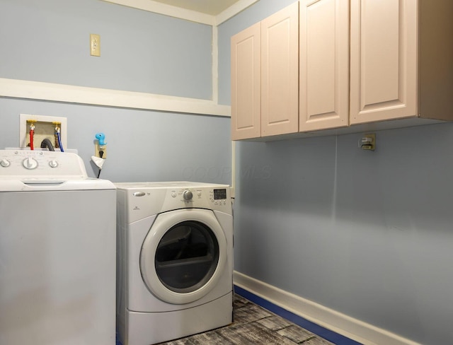 laundry room featuring washing machine and clothes dryer, baseboards, and cabinet space