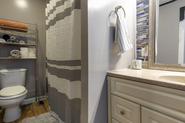 full bath featuring toilet, vanity, a shower with shower curtain, and wood finished floors
