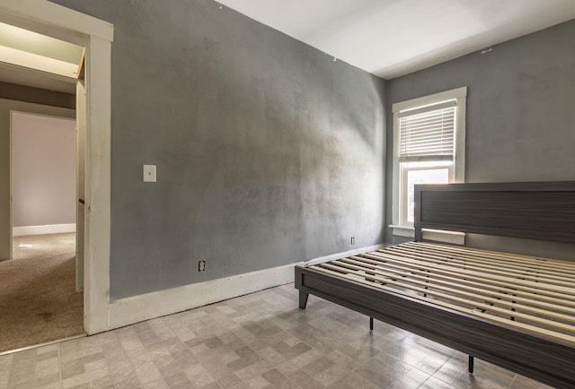 bedroom with tile patterned floors and baseboards