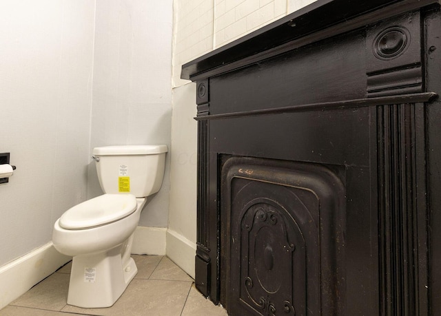 bathroom with toilet, tile patterned flooring, and baseboards