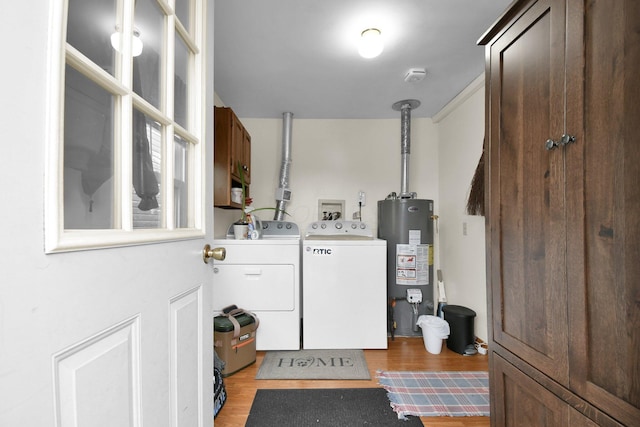 laundry area featuring light wood-style floors, separate washer and dryer, cabinet space, and gas water heater