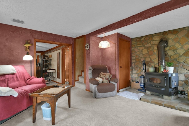 living area with stairway, a wood stove, carpet, and visible vents