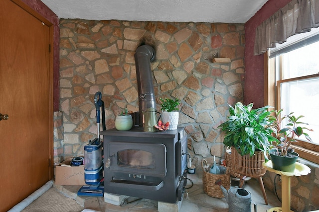 room details featuring a wood stove and a textured ceiling