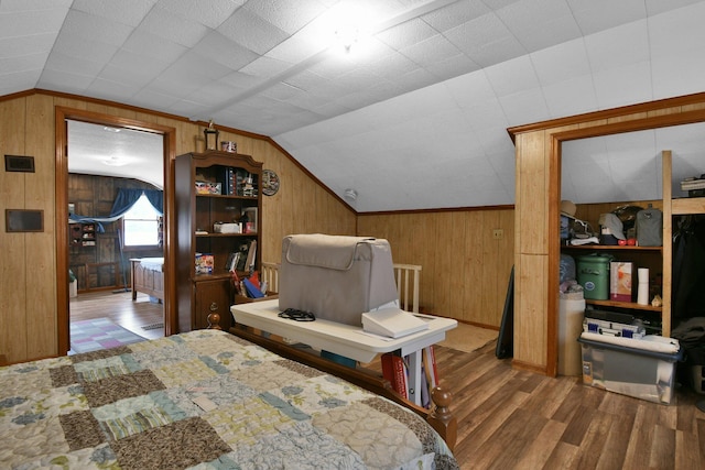 bedroom with wooden walls, wood finished floors, and lofted ceiling