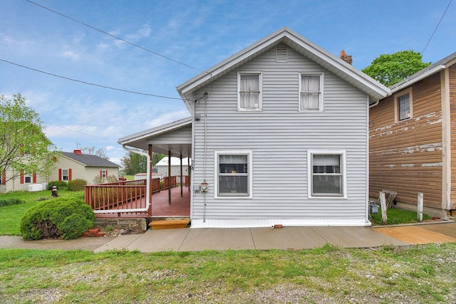 rear view of property with a chimney and a deck