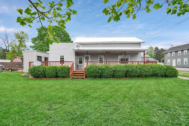 back of house featuring a yard, metal roof, an outdoor structure, and a storage unit