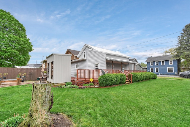 view of home's exterior featuring a yard, a deck, and fence