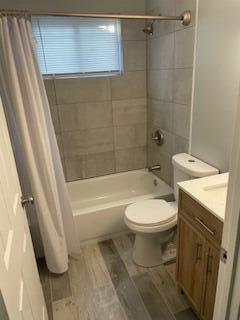 1621 Burley Dr, Columbus, OH 43207 - full bath featuring vanity, shower / bath combo, toilet, and wood finished floors