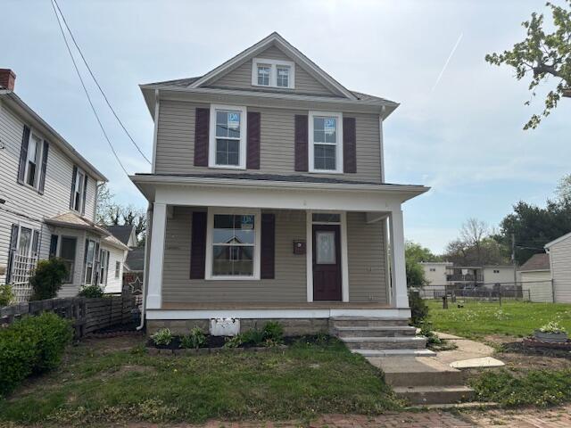traditional style home with a porch and fence