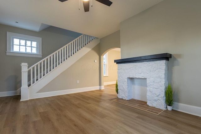 730 Forest Rose Ave, Lancaster, OH 43130 - unfurnished living room featuring a ceiling fan, stairs, wood finished floors, baseboards, and arched walkways