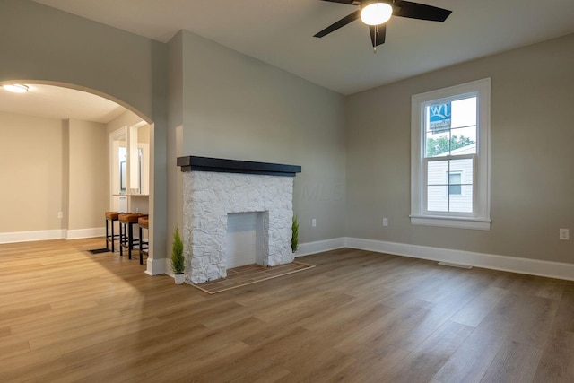 730 Forest Rose Ave, Lancaster, OH 43130 - unfurnished living room featuring ceiling fan, wood finished floors, a stone fireplace, and baseboards