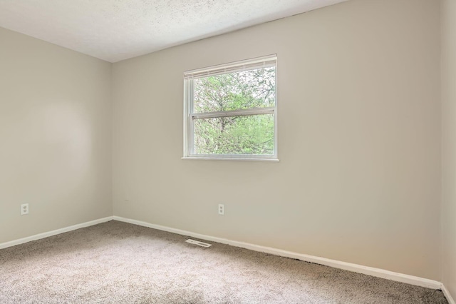 carpeted spare room featuring baseboards