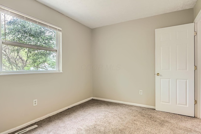 unfurnished room with carpet and baseboards