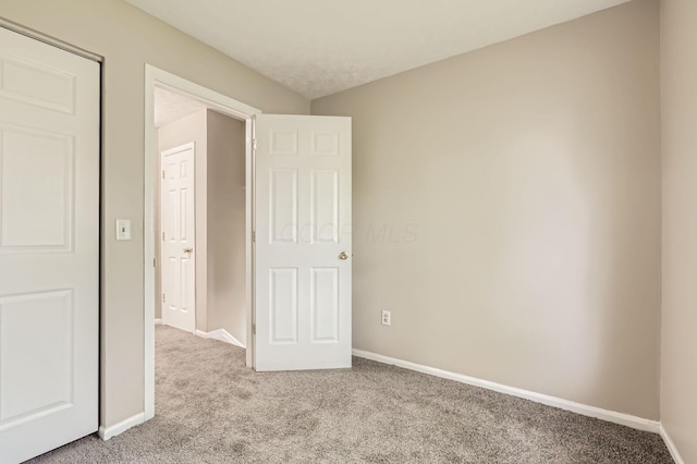 unfurnished bedroom featuring carpet flooring and baseboards