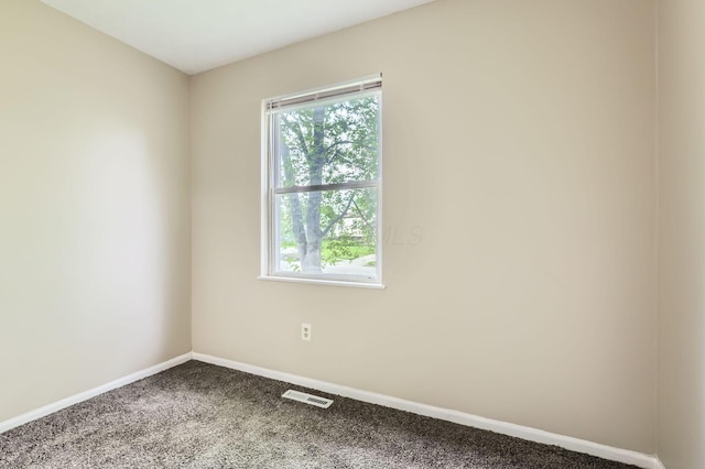 carpeted spare room featuring plenty of natural light and baseboards