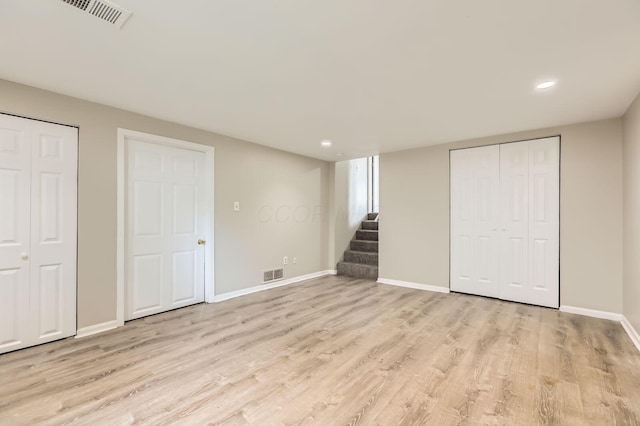 finished basement with stairs, light wood-style floors, baseboards, and recessed lighting