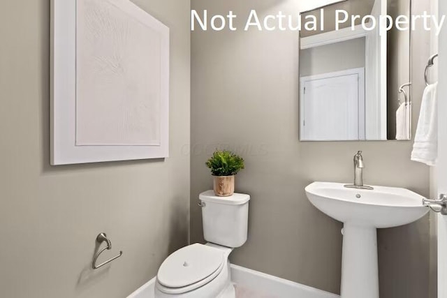 half bath with toilet and baseboards