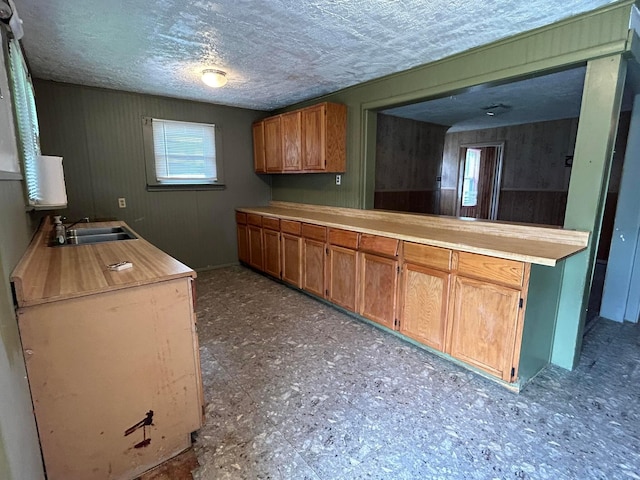 1218 W Mulberry St, Lancaster, OH 43130 - kitchen with brown cabinetry, light countertops, a peninsula, and a sink