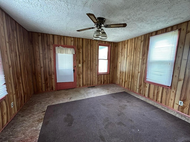 1218 W Mulberry St, Lancaster, OH 43130 - carpeted spare room featuring a textured ceiling, a ceiling fan, visible vents, and wood walls