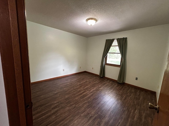 12601 Vincent Rd, Mount Vernon, OH 43050 - spare room with dark wood finished floors, baseboards, and a textured ceiling