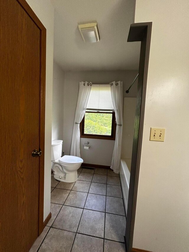 12601 Vincent Rd, Mount Vernon, OH 43050 - bathroom featuring toilet, tile patterned floors, shower / tub combo with curtain, and baseboards