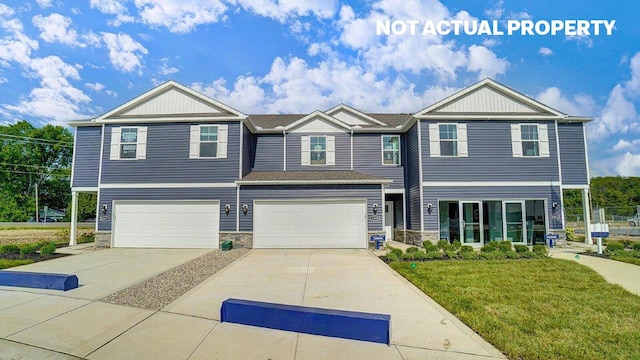 townhome / multi-family property featuring a front yard, a garage, stone siding, and driveway
