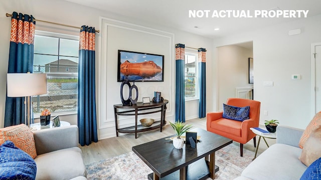 living area with wood finished floors, baseboards, and recessed lighting