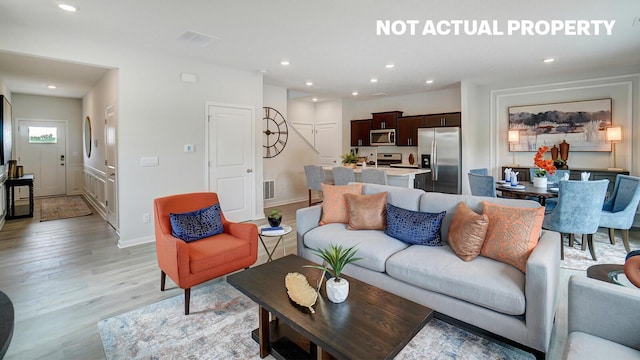 living area with recessed lighting, baseboards, and light wood-style floors