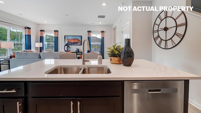 kitchen with a sink, open floor plan, light countertops, and dishwasher