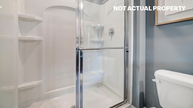 full bath featuring a stall shower and toilet