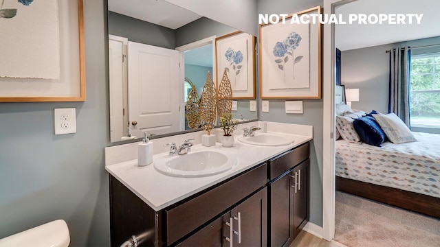 ensuite bathroom with double vanity, toilet, ensuite bathroom, and a sink