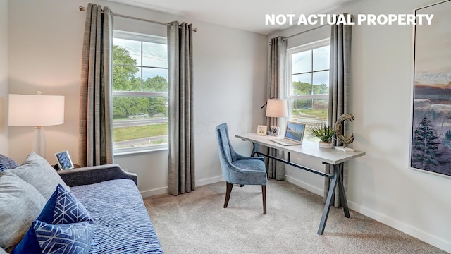 office space featuring light carpet, baseboards, and a healthy amount of sunlight