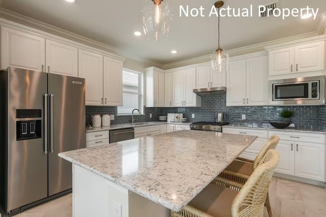 kitchen featuring white cabinetry, stainless steel appliances, decorative backsplash, and a kitchen island